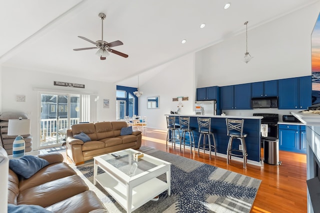 living room featuring ceiling fan, high vaulted ceiling, and hardwood / wood-style floors