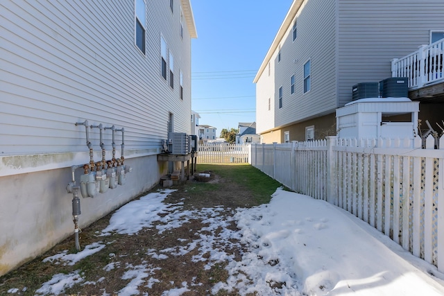 yard layered in snow with central AC unit