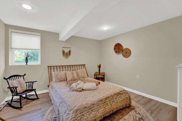 bedroom with beamed ceiling and wood-type flooring