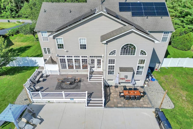 rear view of house featuring solar panels, an outdoor hangout area, a patio, and a wooden deck