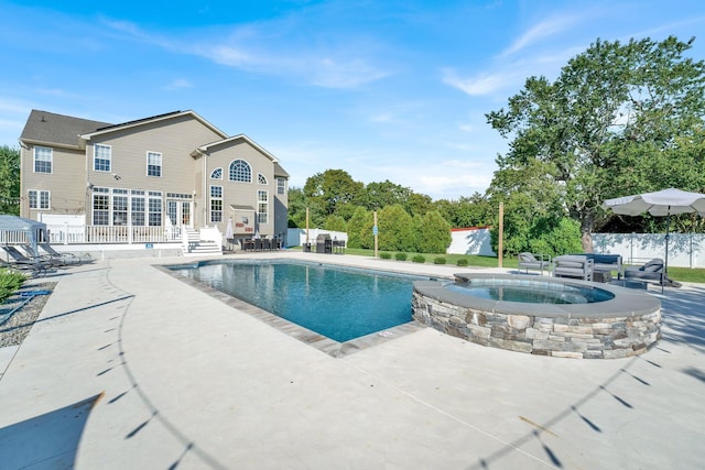 view of swimming pool featuring an in ground hot tub and a patio