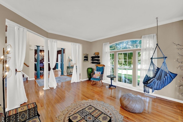 interior space with hardwood / wood-style flooring, crown molding, and decorative columns