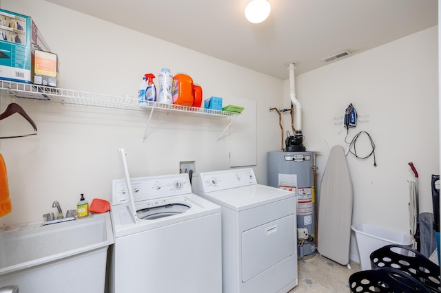 laundry room with water heater, visible vents, a sink, separate washer and dryer, and laundry area