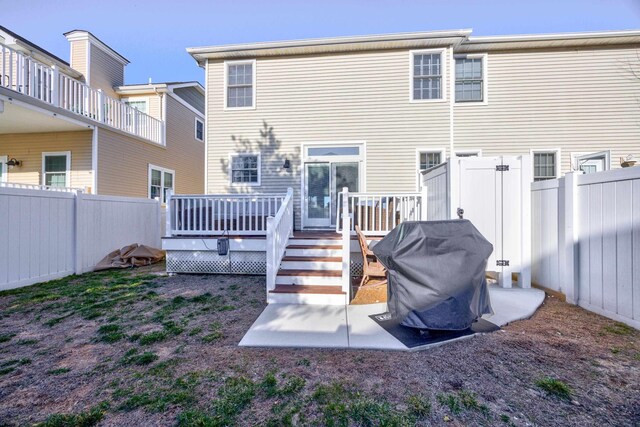 rear view of property with a fenced backyard and a wooden deck