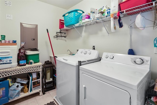 washroom with electric panel, washer and clothes dryer, and light tile patterned floors