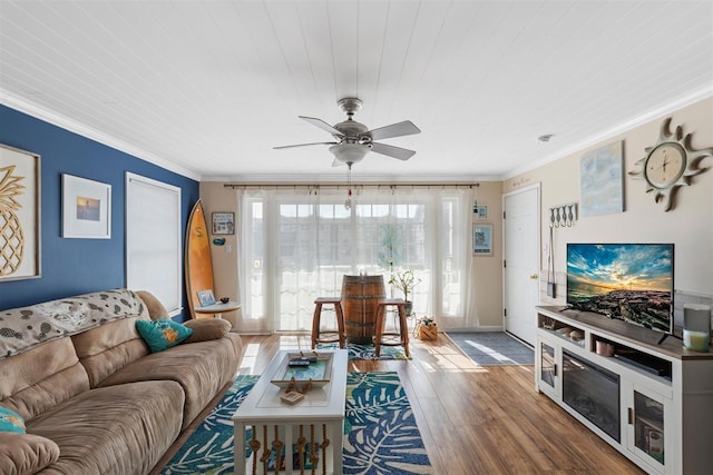 living room featuring hardwood / wood-style flooring, ceiling fan, and ornamental molding