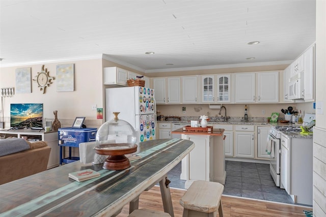 kitchen featuring crown molding, white appliances, light stone countertops, and white cabinets