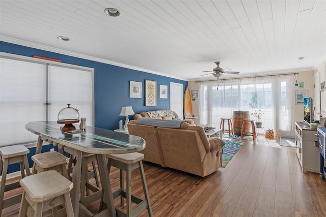 living room with wood ceiling, crown molding, dark wood-type flooring, and ceiling fan