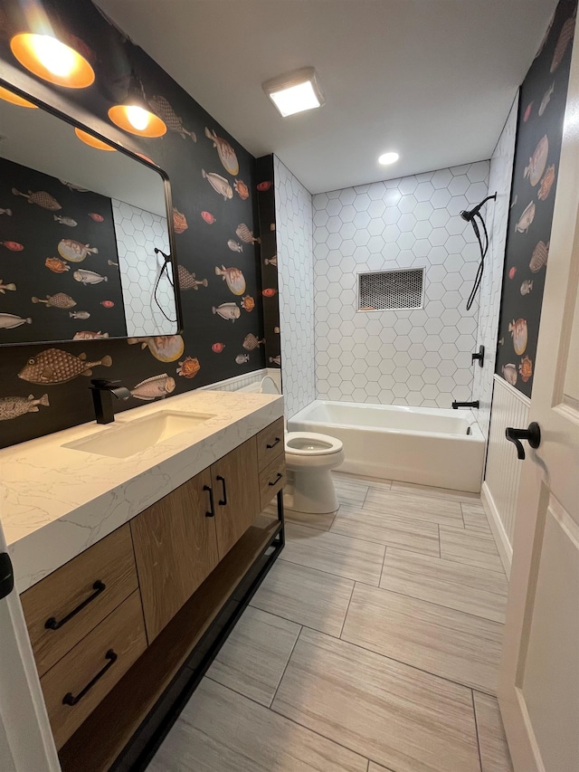 full bathroom featuring toilet, vanity, and tiled shower / bath