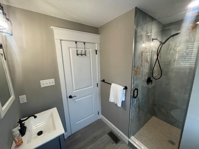 bathroom featuring vanity, hardwood / wood-style flooring, and walk in shower