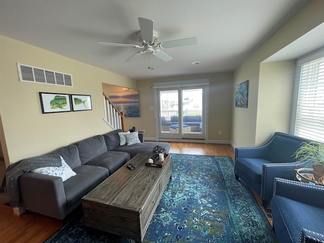 living room with ceiling fan and dark wood-type flooring