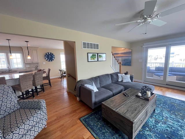 living room with ceiling fan, sink, and light hardwood / wood-style flooring