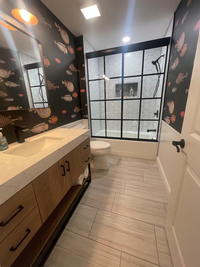 full bathroom featuring vanity, toilet, and shower / bath combination with glass door