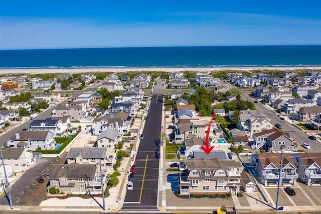 drone / aerial view with a water view and a beach view