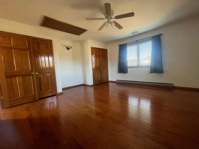 unfurnished bedroom with baseboard heating, ceiling fan, and dark hardwood / wood-style flooring