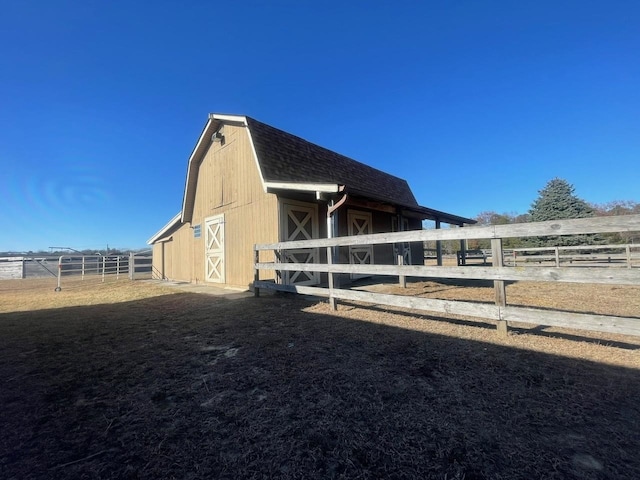 view of property exterior with an outbuilding and a rural view