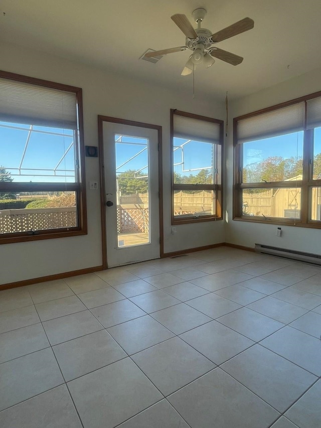 unfurnished sunroom with ceiling fan, baseboard heating, and a wealth of natural light