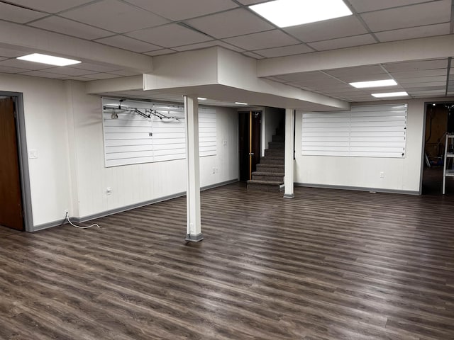 basement featuring dark hardwood / wood-style flooring and a drop ceiling