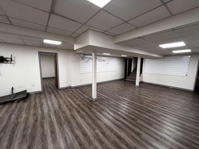 basement with a drop ceiling and dark hardwood / wood-style floors