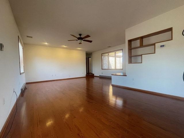 unfurnished living room with ceiling fan and dark wood-type flooring