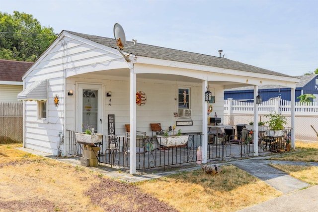 bungalow with a shingled roof and fence