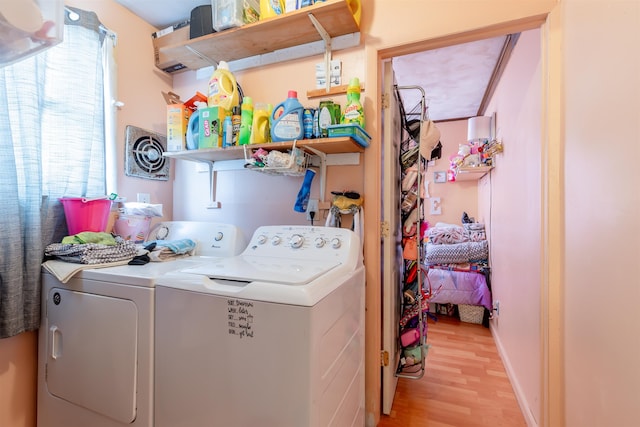 washroom featuring light wood-style floors, laundry area, plenty of natural light, and washing machine and clothes dryer