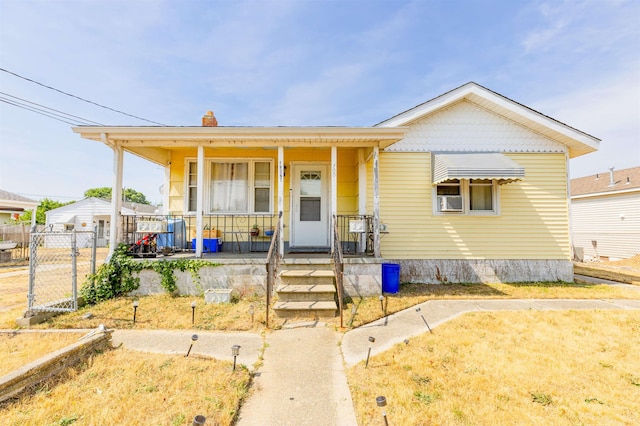 view of front facade with cooling unit, covered porch, and fence