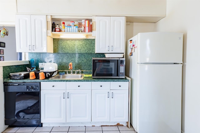 kitchen with tasteful backsplash, dark countertops, white cabinets, a sink, and black appliances