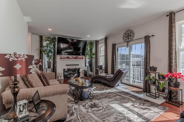 living room with recessed lighting, a fireplace, and wood finished floors