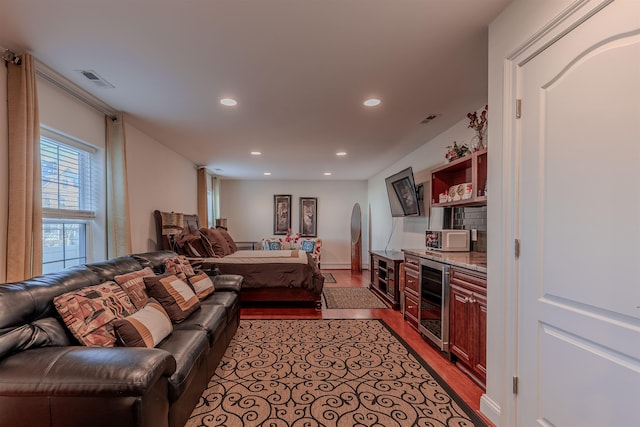 living room featuring beverage cooler, light wood-type flooring, visible vents, and recessed lighting