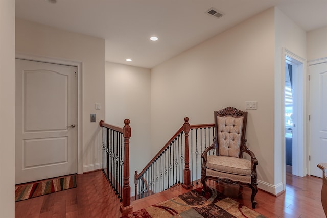 stairway with baseboards, wood finished floors, visible vents, and recessed lighting