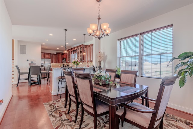 dining area with light wood finished floors, baseboards, visible vents, a notable chandelier, and recessed lighting