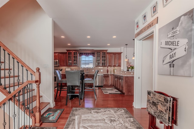 dining room featuring dark wood-type flooring, recessed lighting, and stairway