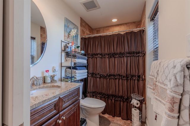 bathroom featuring toilet, stone finish flooring, vanity, and visible vents