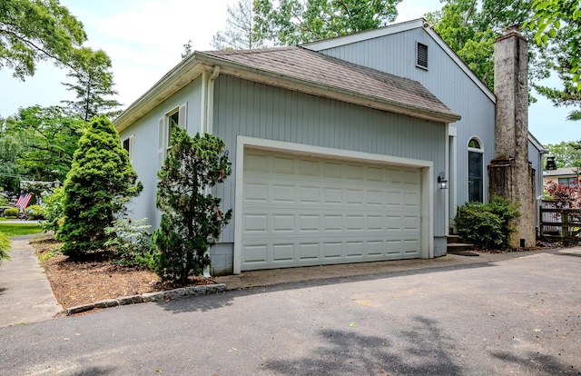970 Shirley Ave, Erma, NJ 08204 - view of side of home featuring a shingled roof, an attached garage, asphalt driveway, and a chimney