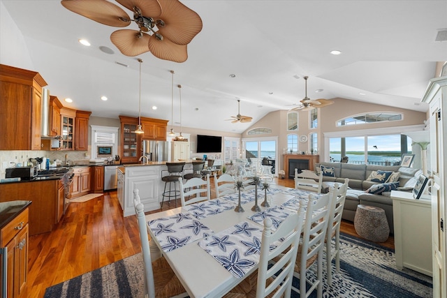 dining space with dark hardwood / wood-style flooring, vaulted ceiling, and sink