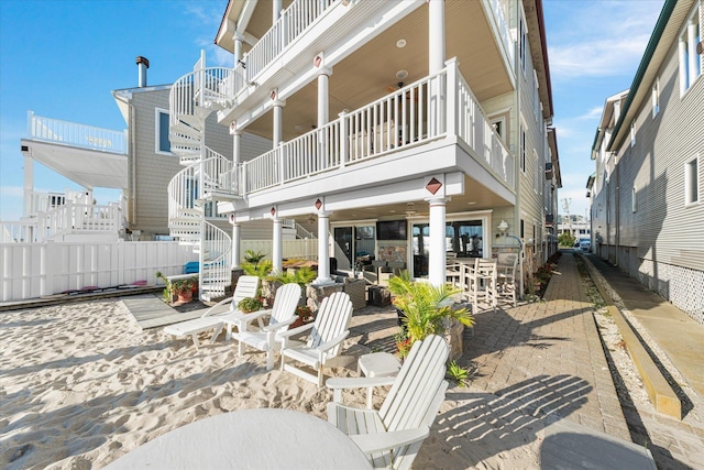 rear view of house featuring a balcony, an outdoor bar, and a patio