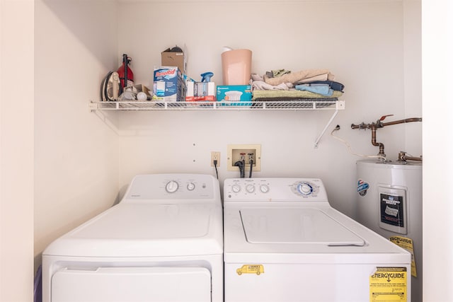clothes washing area with independent washer and dryer, laundry area, and water heater