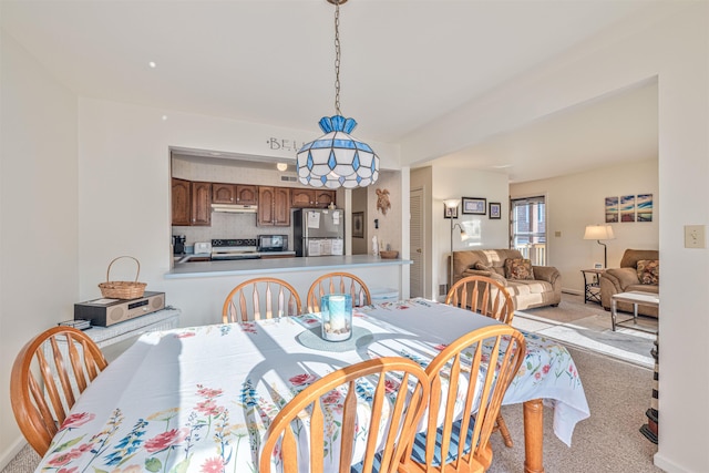 dining area featuring light carpet