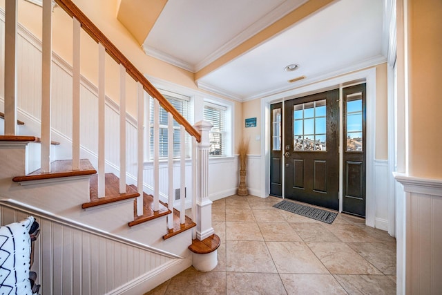 tiled entrance foyer featuring crown molding