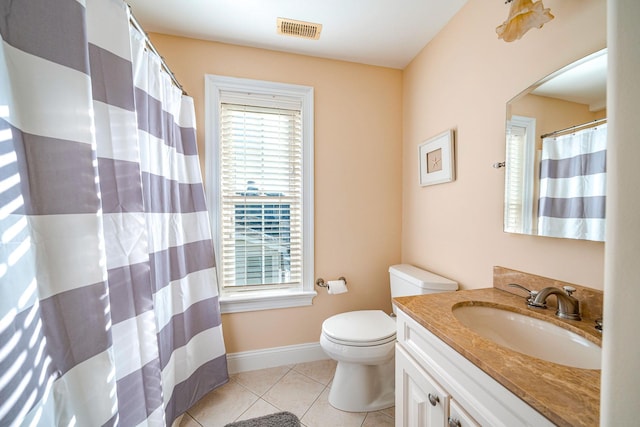 bathroom with tile patterned floors, toilet, vanity, and plenty of natural light