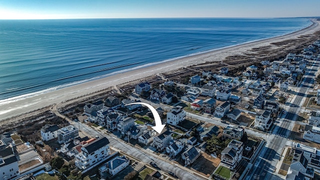 drone / aerial view featuring a water view and a beach view