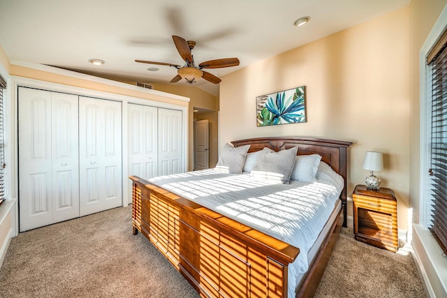 carpeted bedroom with ceiling fan and multiple closets