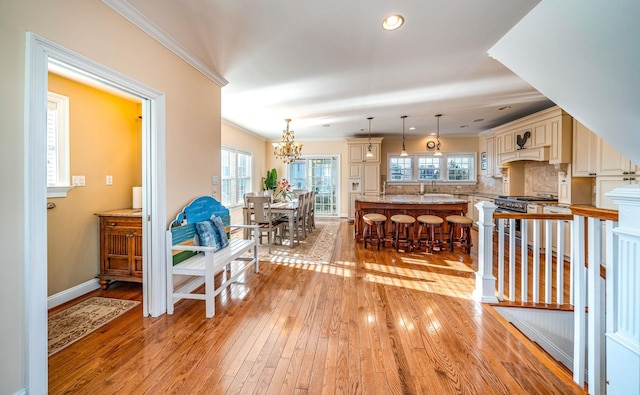 interior space featuring ornamental molding, a chandelier, and light hardwood / wood-style flooring