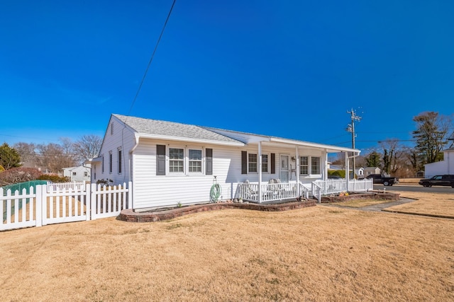 view of front of property with a porch, roof with shingles, fence, and a front lawn