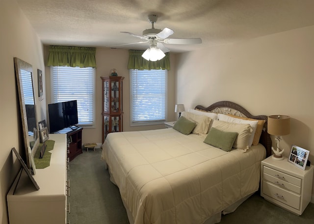 bedroom with ceiling fan, carpet floors, and a textured ceiling