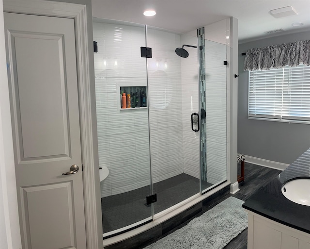 bathroom featuring an enclosed shower, vanity, and hardwood / wood-style floors