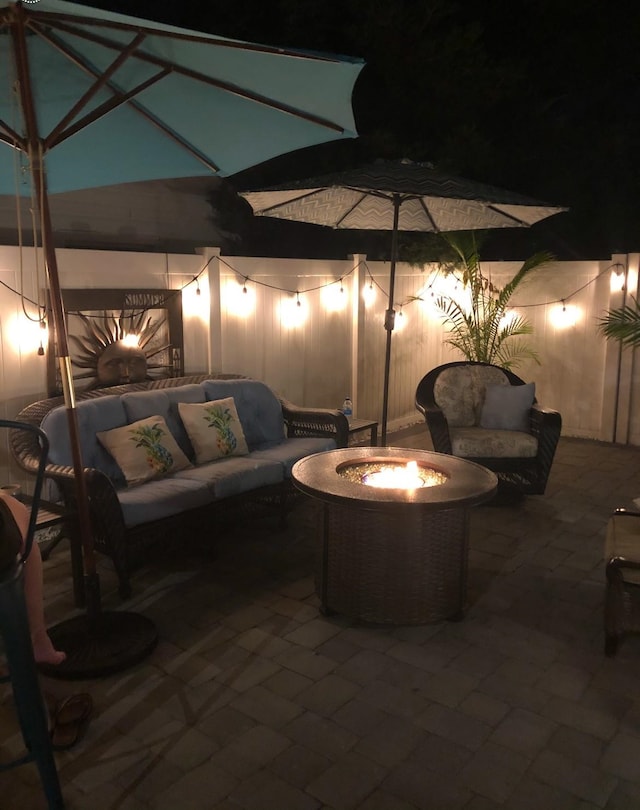 patio at twilight featuring an outdoor living space with a fire pit