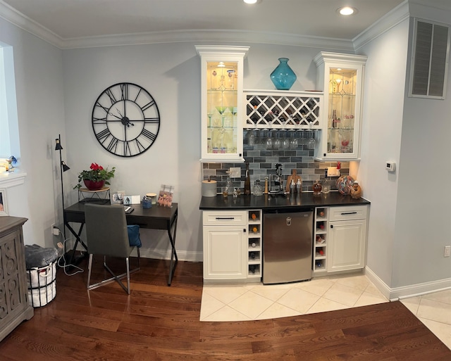 bar with refrigerator, light tile patterned flooring, crown molding, and backsplash