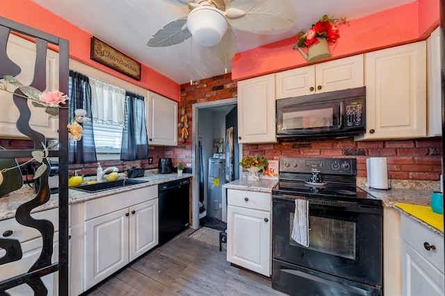 kitchen with light countertops, white cabinets, a sink, and black appliances